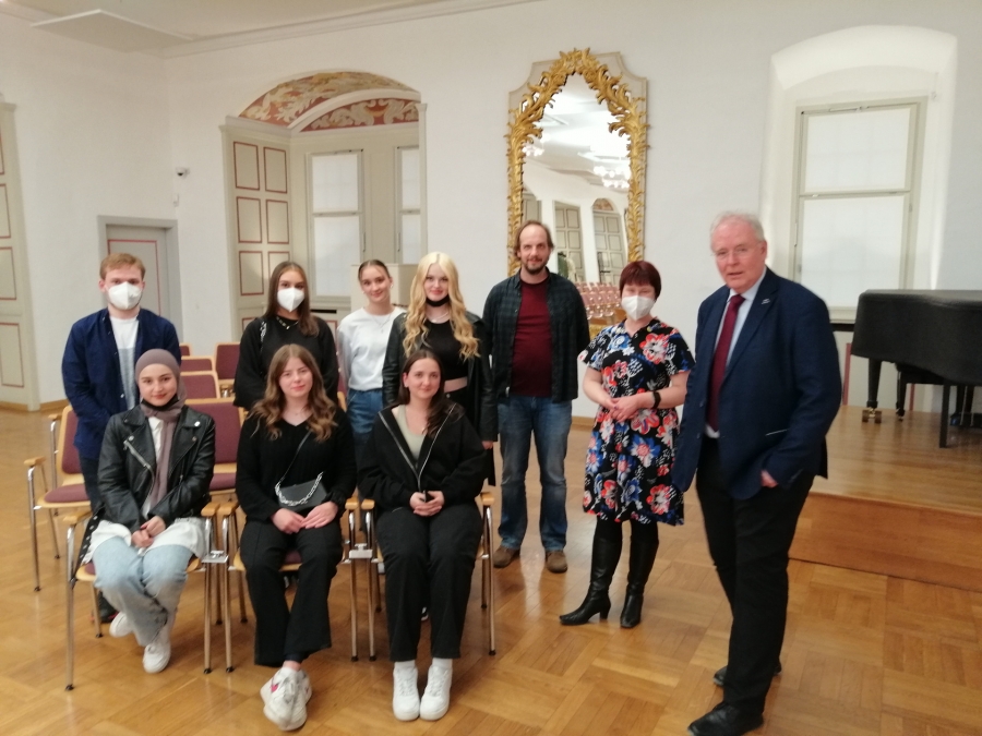 Ein Gruppenbild vor der historischen Ansicht des Neuhäuser Schlosses im Audienzsaal -   Zeitgeschichtlicher Vortrag zum Militärischen Widerstand 